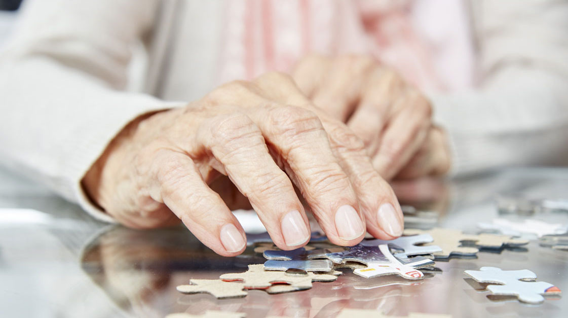 senior hands with puzzle pieces